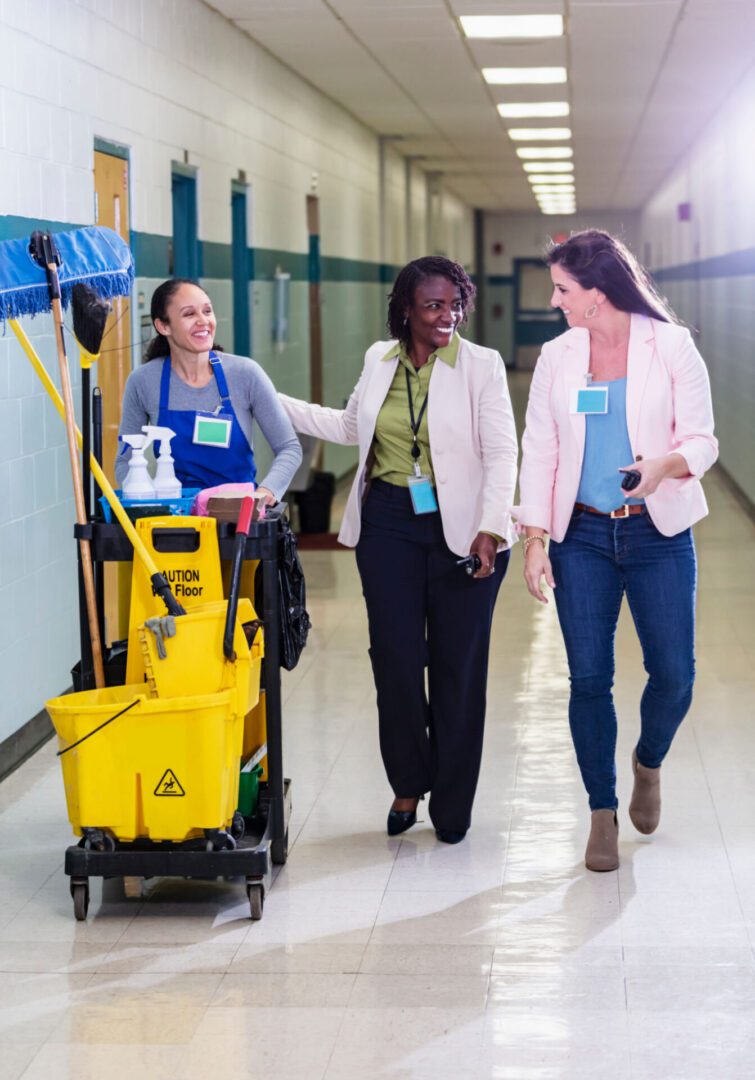 Three women walking in a school hallway.